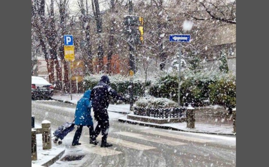 Dok pada prvi snijeg, policajac pomaže baki da pređe ulicu